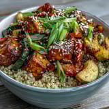 An overhead view of the Quinoa Vegetable Teriyaki Bowl, drizzled with glossy sauce and topped with sesame seeds.