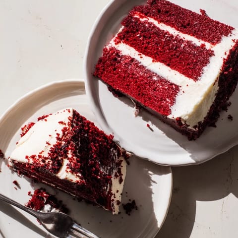 A classic Southern Red Velvet Cake covered in creamy frosting, garnished with crumbs, ready to serve at birthday parties and celebrations.