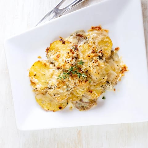 Tender slices of Yukon Gold potatoes soak up the creamy garlic sauce in this classic Au Gratin Potatoes side dish.