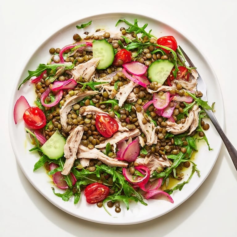 Fresh ingredients for Lentil & Chicken Spring Salad, including cooked lentils, roasted chicken, arugula, and zesty Dijon dressing.