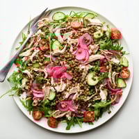 The Lentil & Chicken Spring Salad features tender lentils, juicy shredded chicken, and peppery arugula tossed in a tangy mustard dressing.  